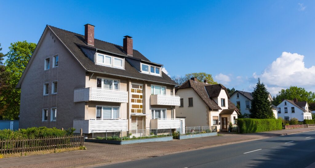 Älteres Mehrfamilienhaus an einer Hauptstraße